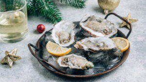 Plateau d'huîtres creuses ouvertes sur glace pilée avec citron pour un repas de Noël