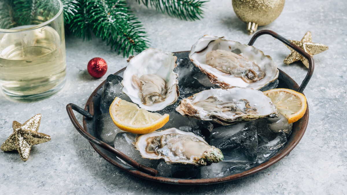 Plateau d'huîtres creuses ouvertes sur glace pilée avec citron pour un repas de Noël