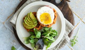 Petit déjeuner salé avec tartines, œufs, légumes frais et fromage