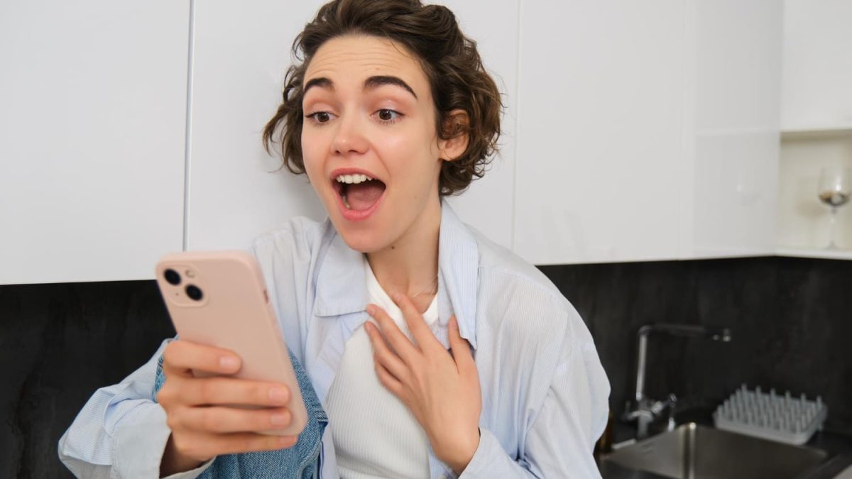 femme regarde son mobile excitée