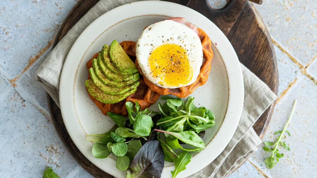 Petit déjeuner salé avec tartines, œufs, légumes frais et fromage