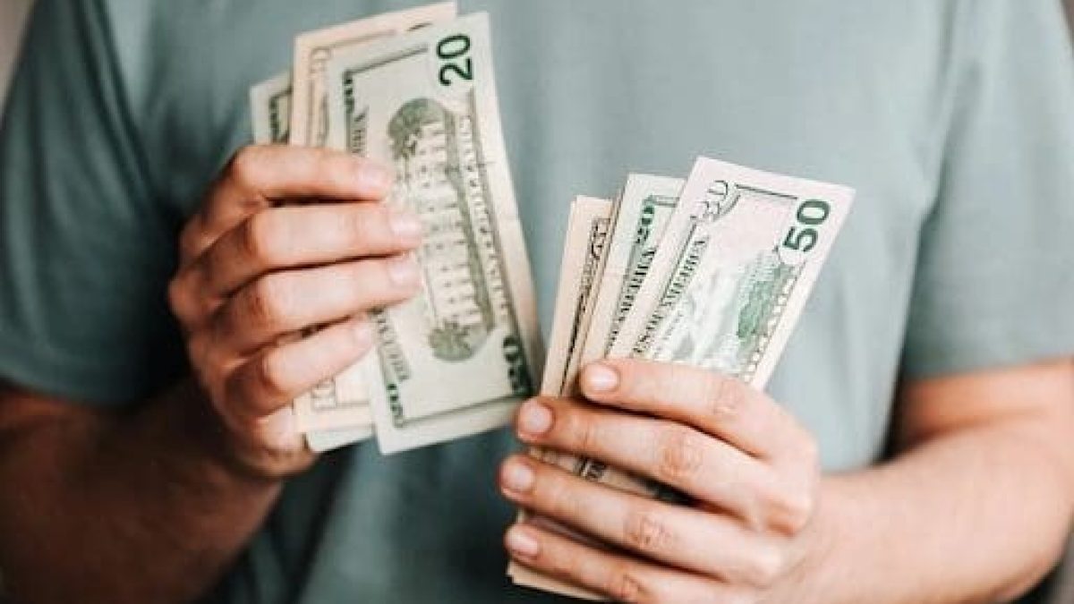 une personne tient billets dans la main